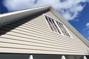House exterior, against a blue sky. Roof close-up. Low angle view. Siding Installation on home Geo City